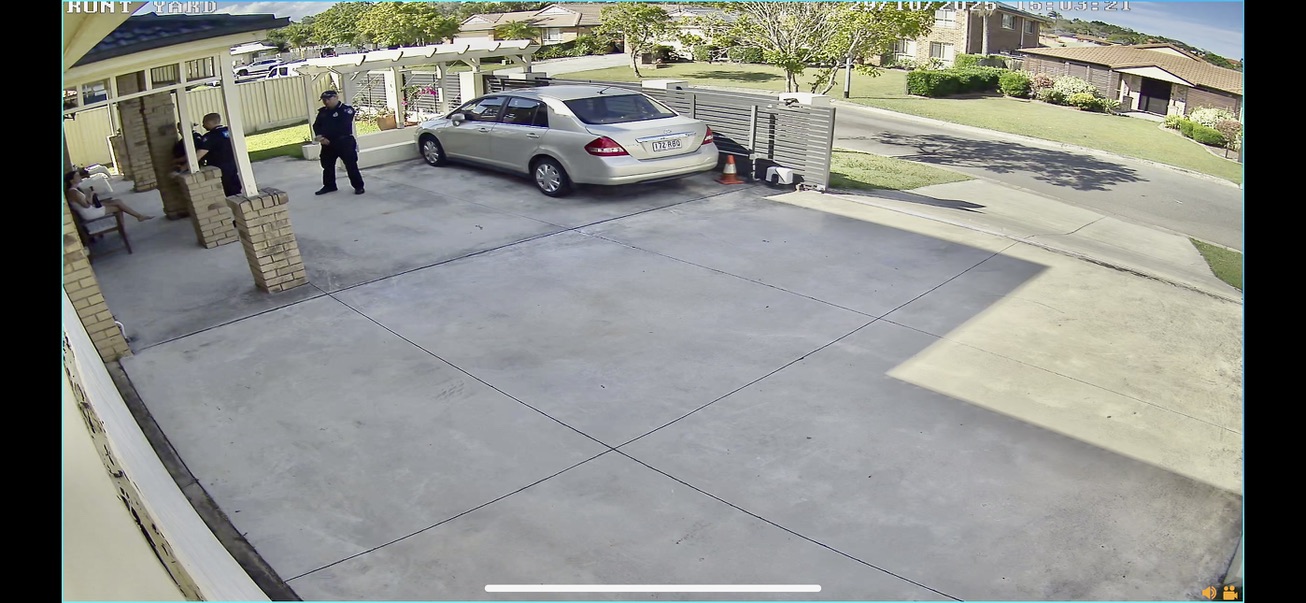 Front yard CCTV 14:56:13 — three officers on the driveway, 29 October 2025